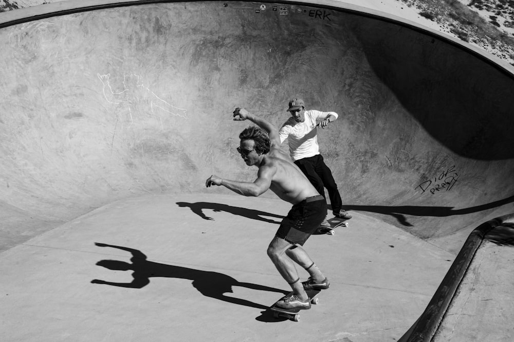 Hombre con camisa blanca y pantalones cortos negros saltando en patineta