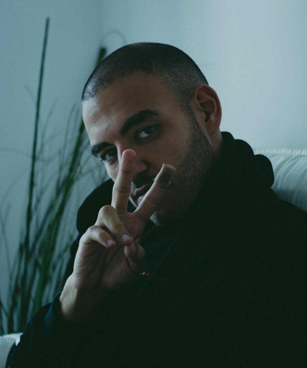 man in black sweater smoking cigarette