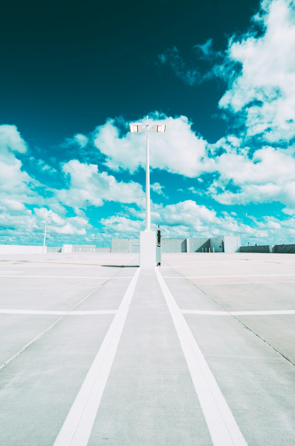 gray concrete road under blue sky and white clouds during daytime