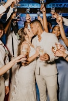 man in white suit holding woman in white dress