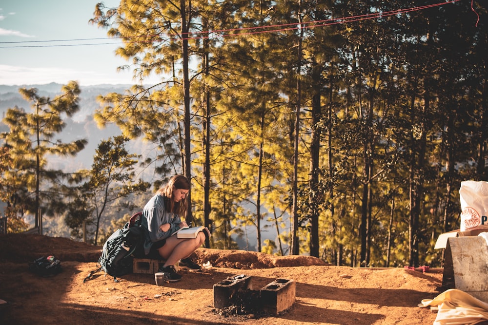 man in blue t-shirt sitting on brown wooden bench during daytime