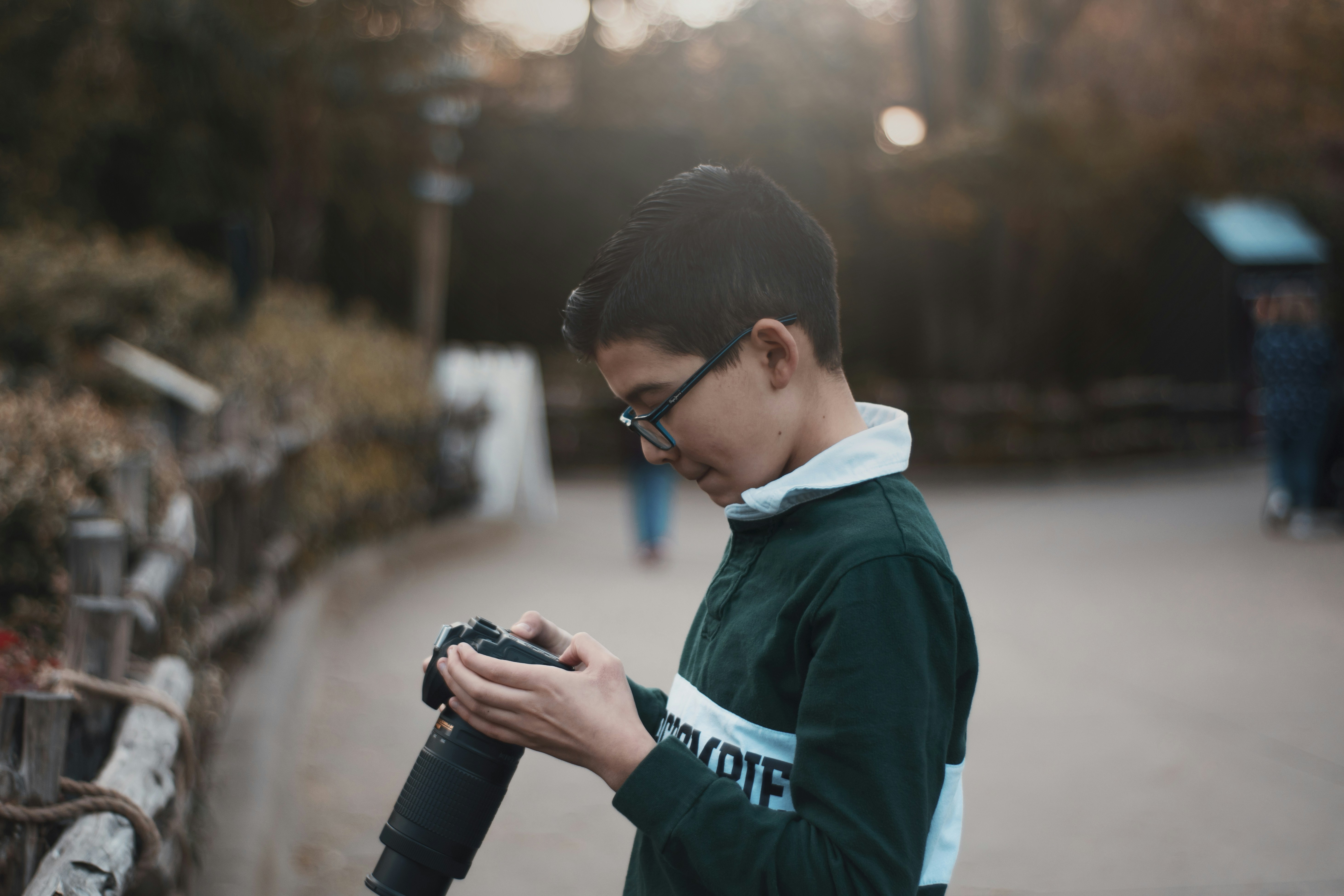 man in blue and white jacket holding black dslr camera