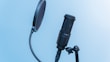 Professional streaming microphone with pop filter set against a colorful LED-lit backdrop.