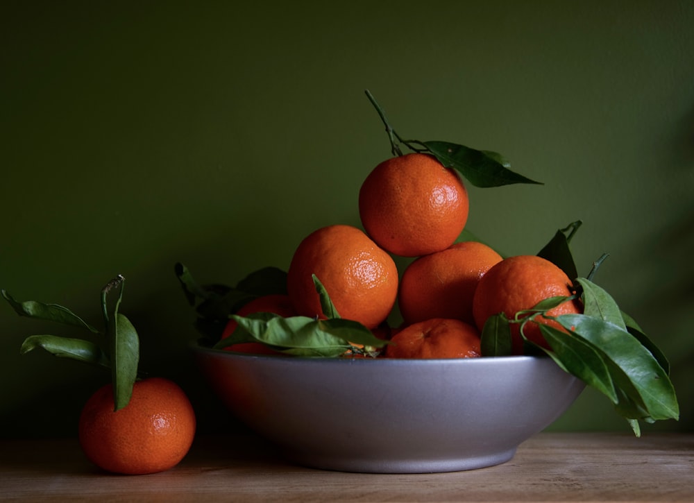 orange fruits on blue ceramic bowl
