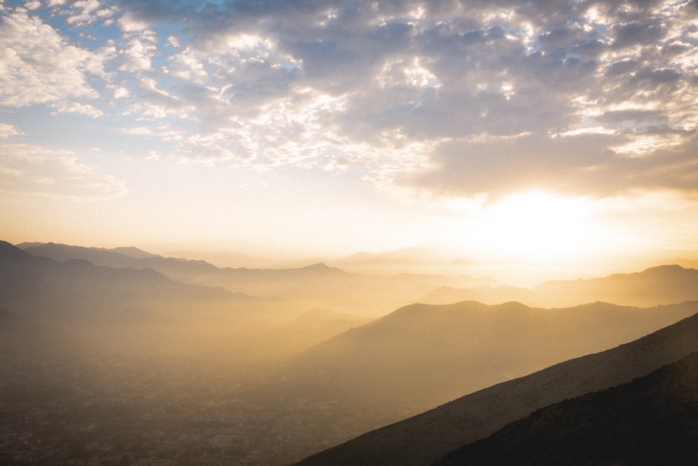 silhouette of mountains under cloudy sky during daytime