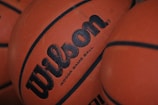 Close-up of several basketballs with visible brand text 'Wilson' and textured surface.