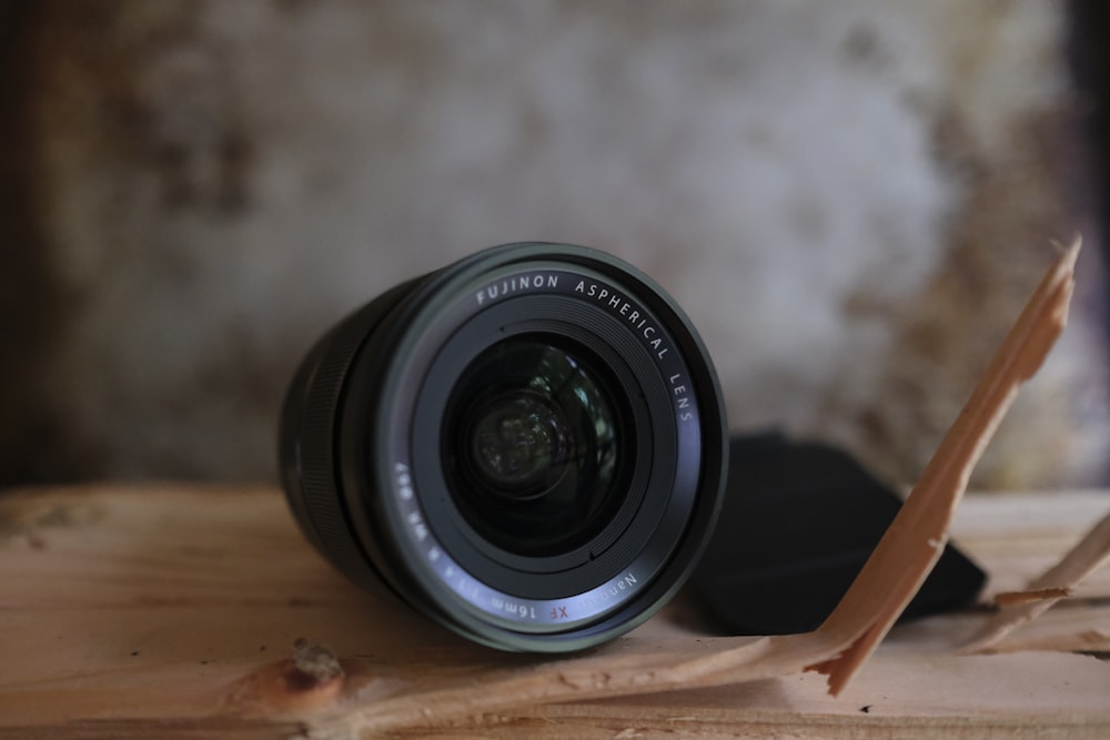 black nikon camera lens on brown wooden table