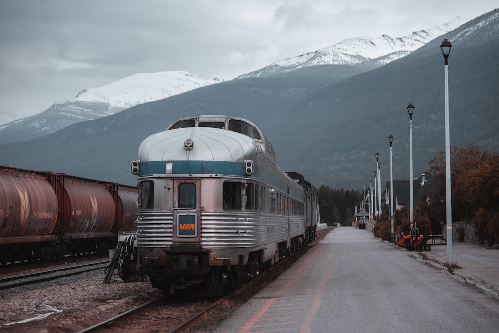 red and black train on rail tracks near snow covered mountain during daytime