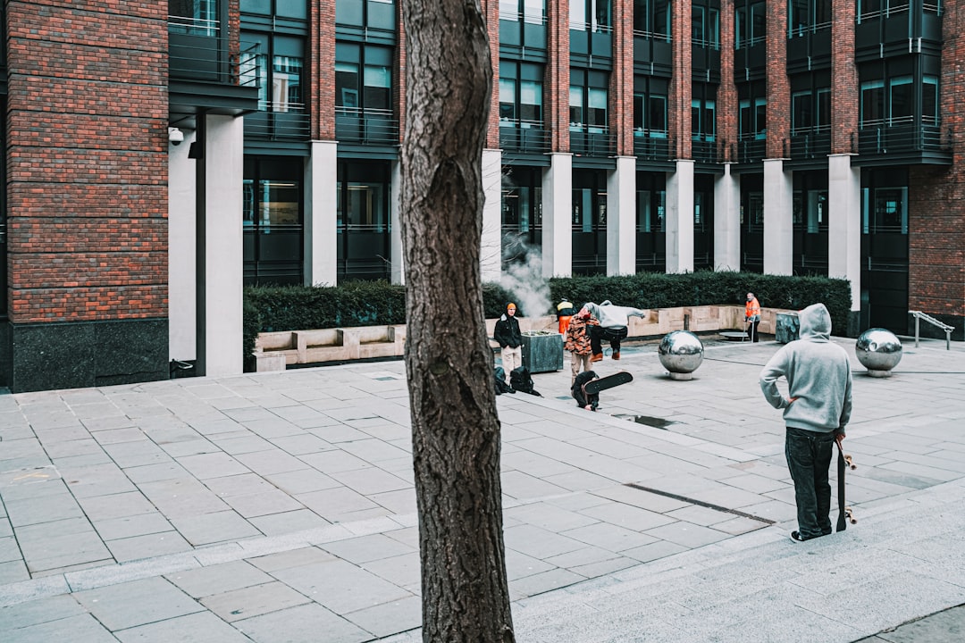 people walking on sidewalk near brown bare trees during daytime