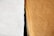 A close-up view of a stack of brown paper sheets next to a single white textured sheet, showcasing the contrast between the two surfaces.