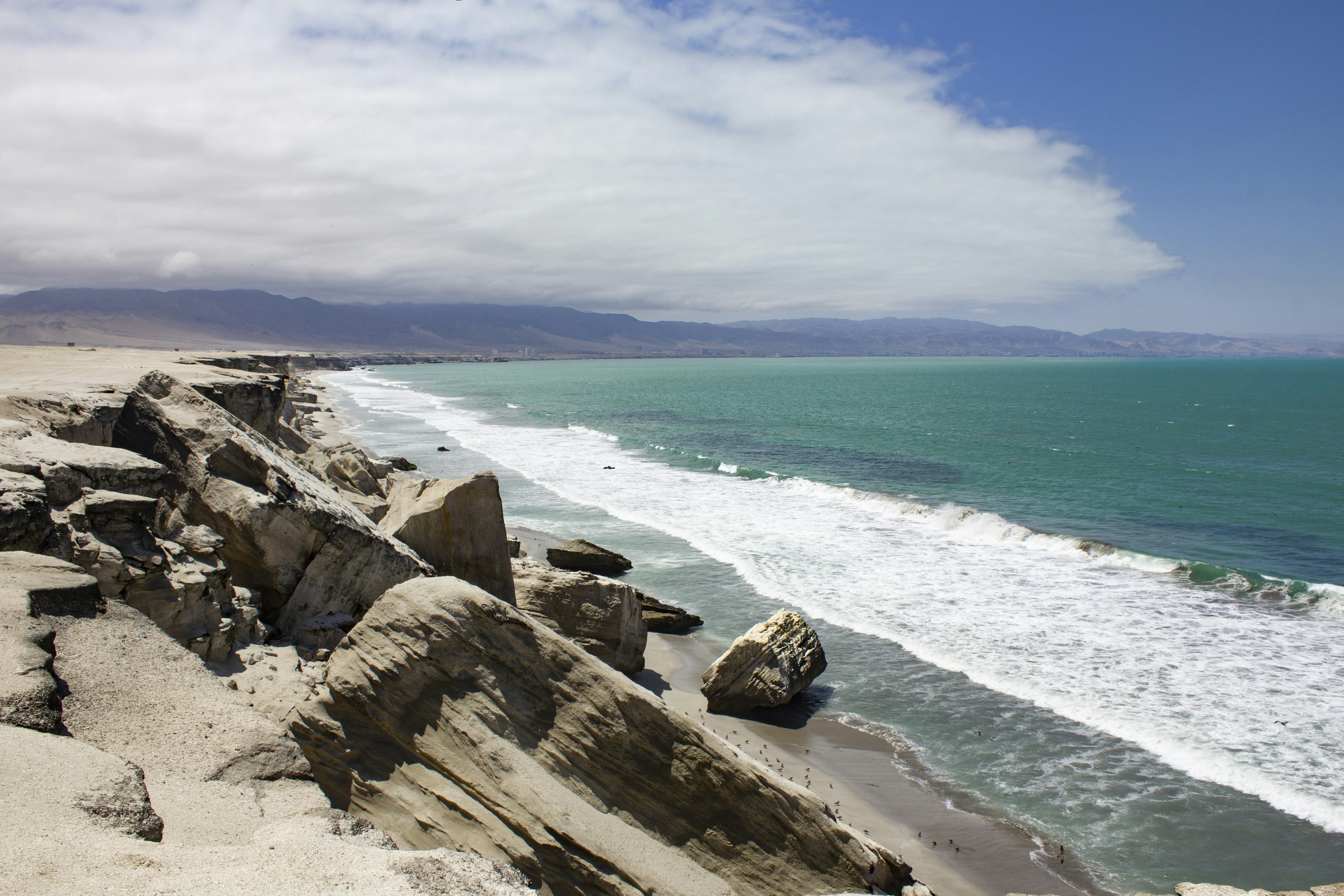brown rock formation near body of water during daytime