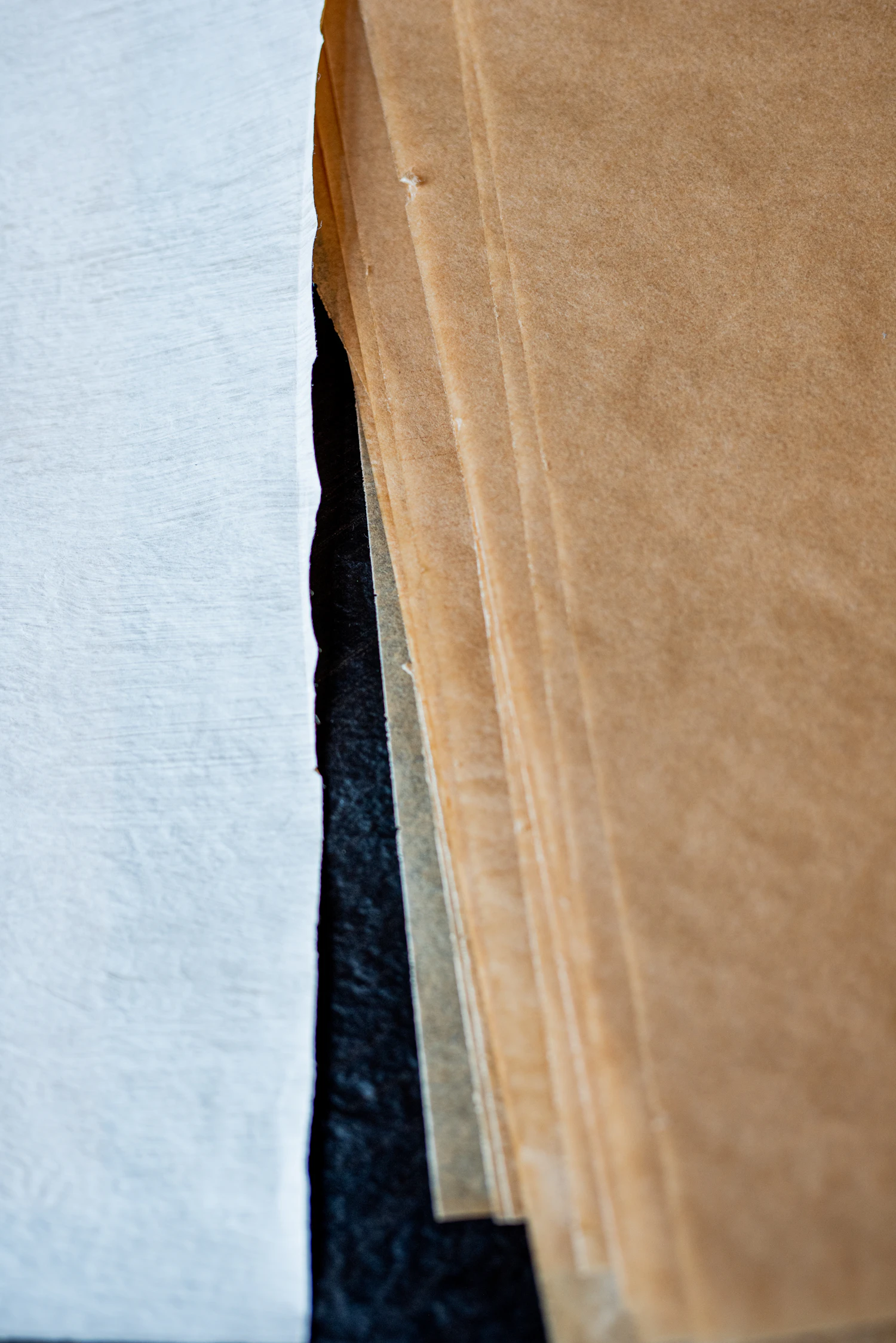 The edges of stacked kraft and white kozo offcuts