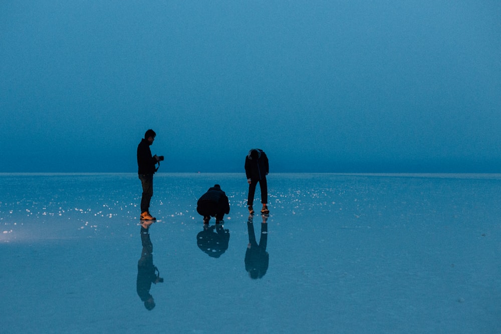 2 women in black shirt and black pants standing on water during daytime