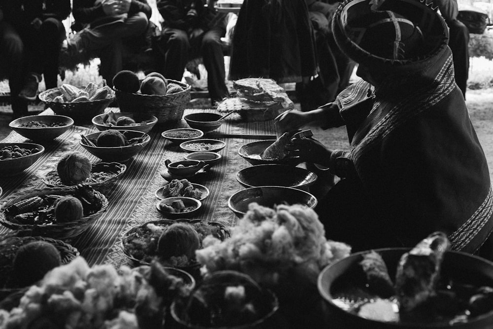 grayscale photo of people eating on table