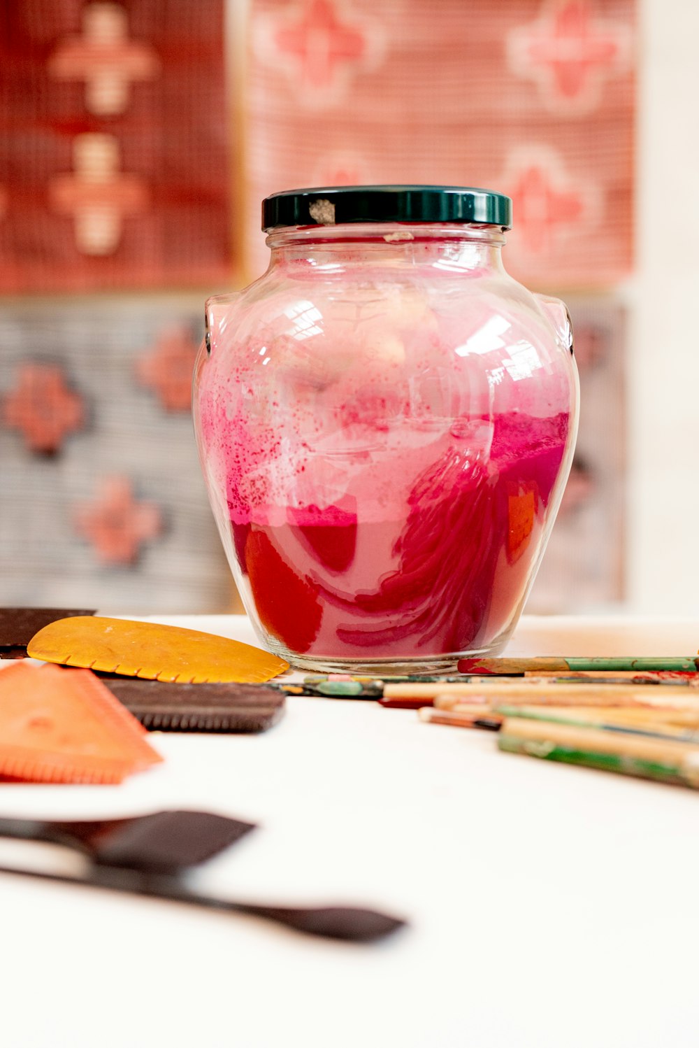 red glass jar with black lid