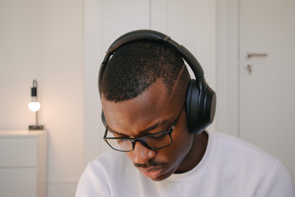 man in white crew neck shirt wearing black headphones