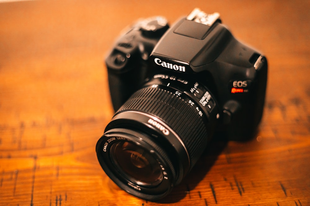 black nikon dslr camera on brown wooden table