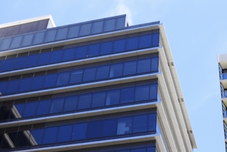 A sleek condo building with blue glass windows reflecting the Houston skyline.
