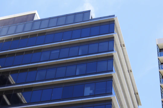 A sleek new urban building with clean lines and glass facades reflecting the sky.