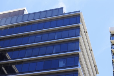 A sleek condo building with blue glass windows reflecting the Houston skyline.