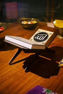 A beautifully crafted wooden bookstand holding an open vintage book near a softly lit window.