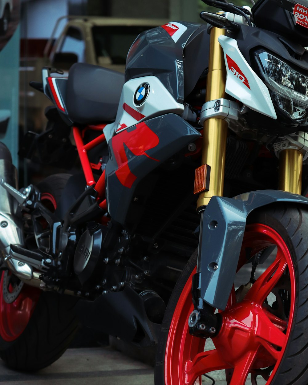 black and red motorcycle parked beside brown wooden pole