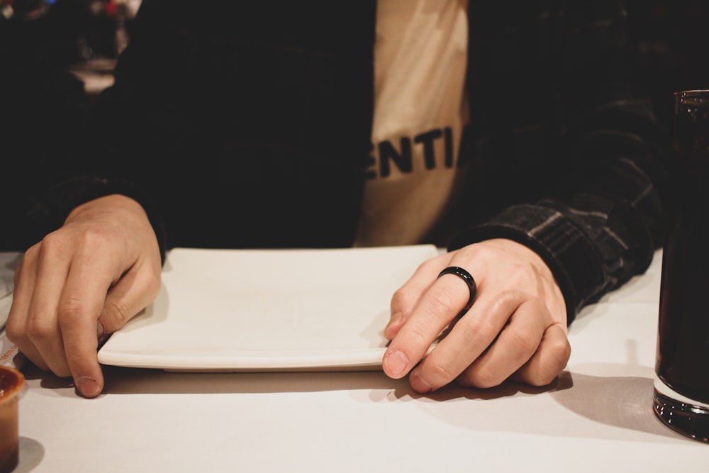 person in black long sleeve shirt holding white book