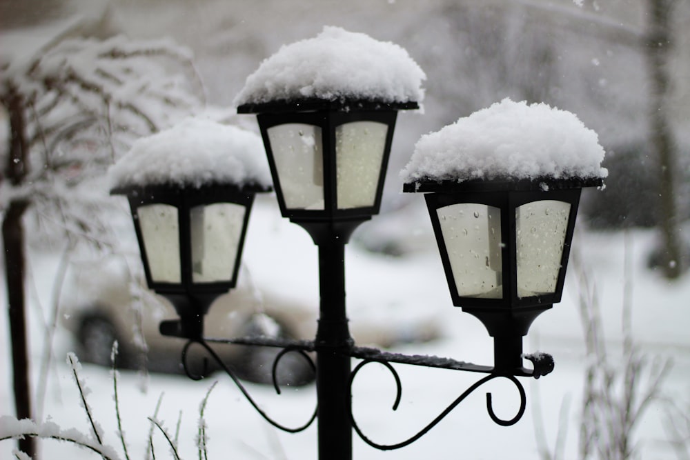 black metal lamp post covered with snow