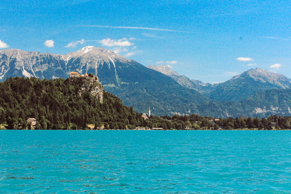 green and brown mountain beside blue sea under blue sky during daytime