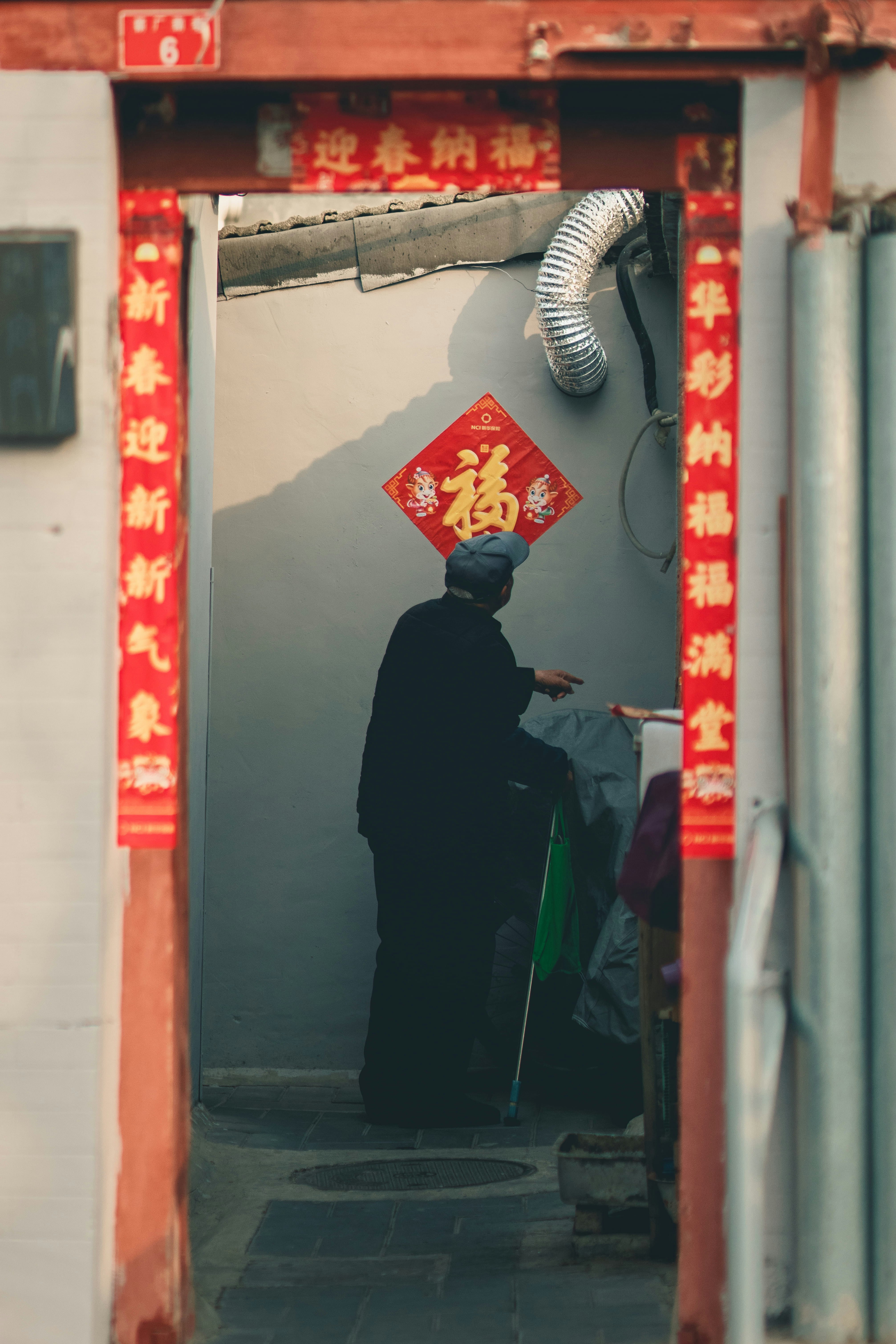 man in black thobe standing near red and white wall