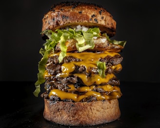 Stacked cheeseburger with crispy bacon and caramelized onions on a toasted bun