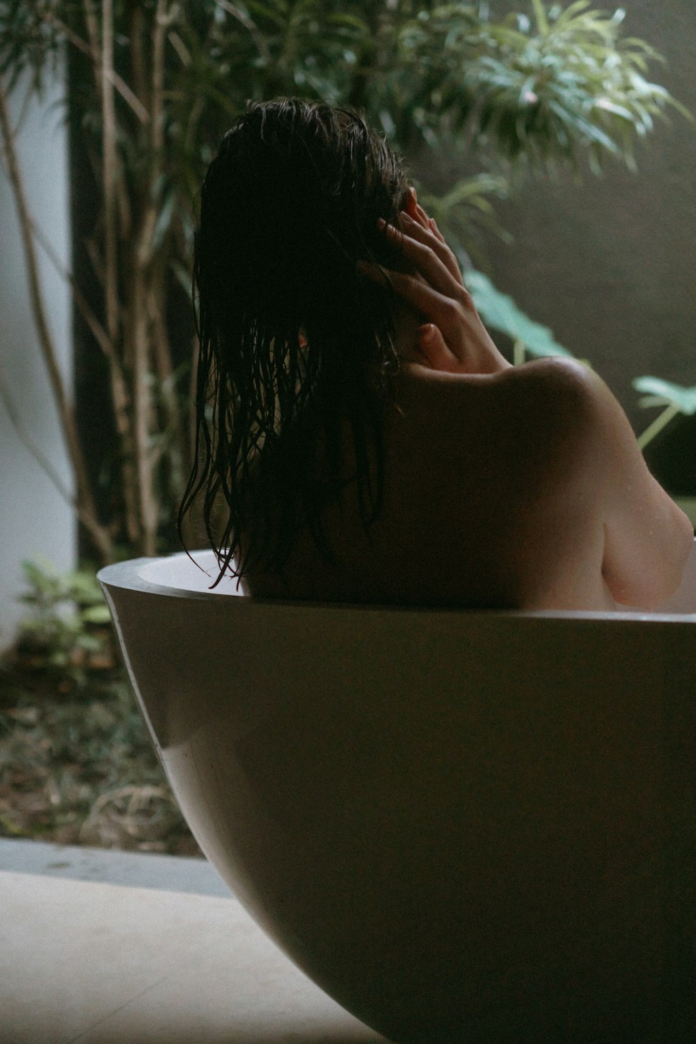 topless woman lying on bathtub