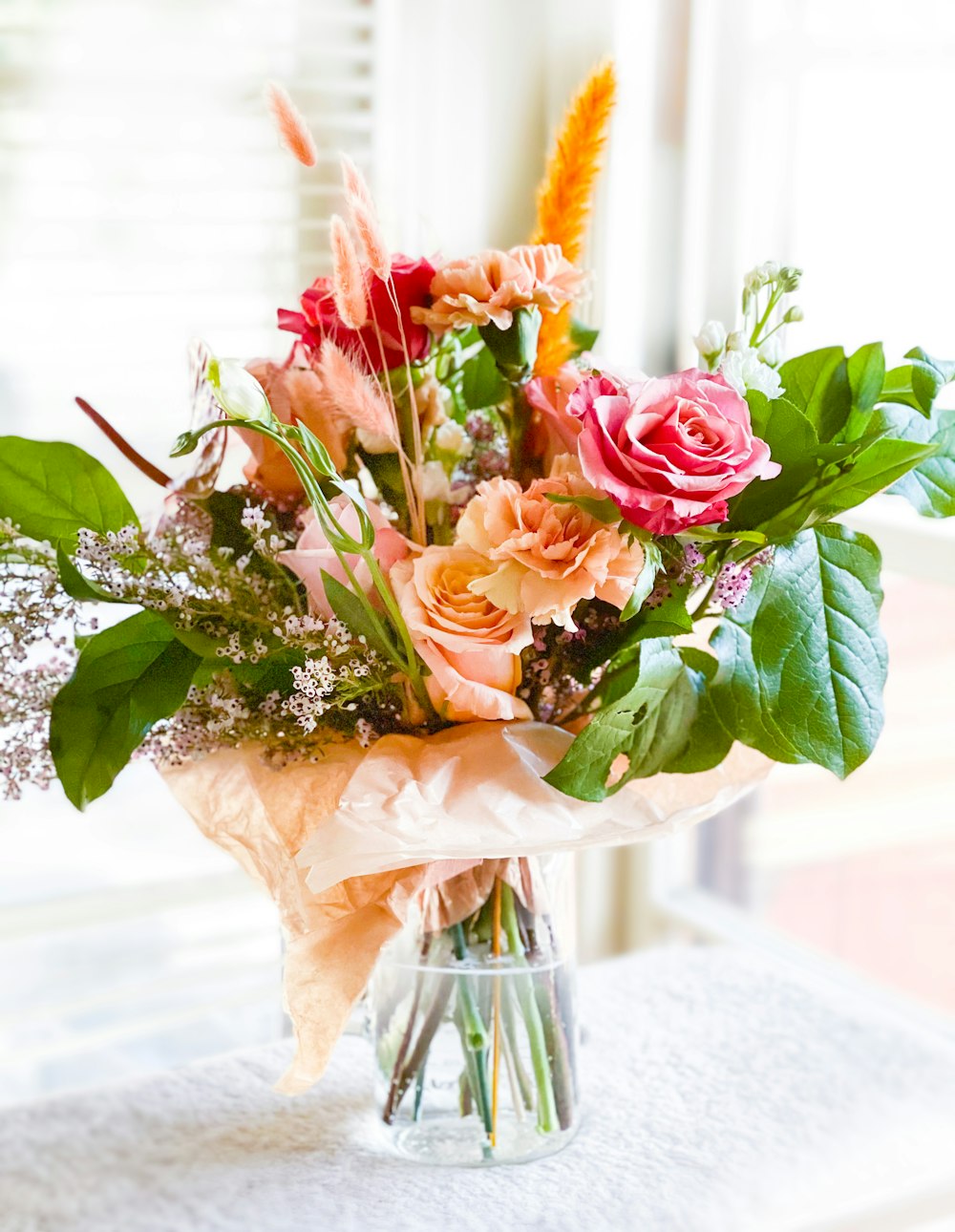 Roses roses dans un vase en verre transparent