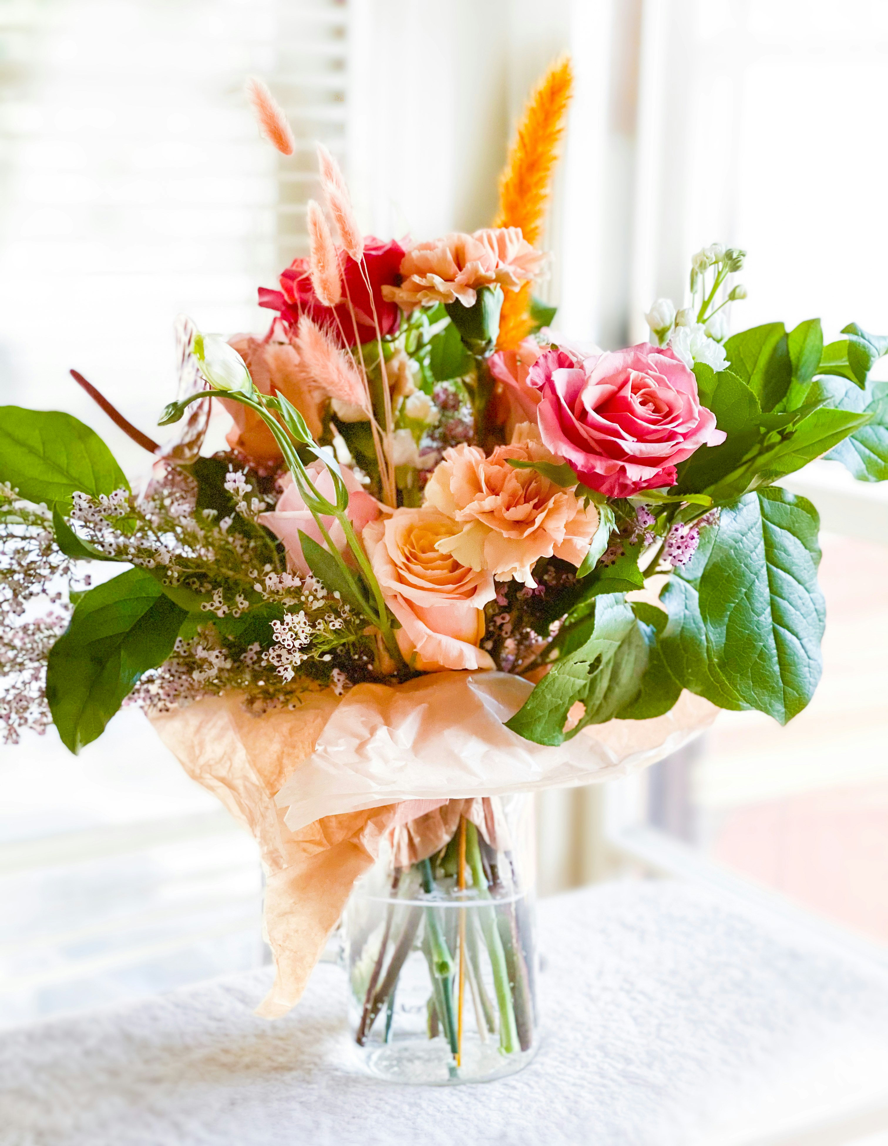 A beautiful modern bouquet of flowers with roses that is arranged in a boho style.