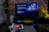 black flat screen tv turned on near brown brick wall