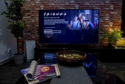 black flat screen tv turned on near brown brick wall