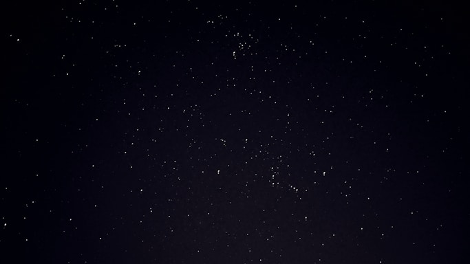 A serene night sky filled with stars and a telescope pointing upwards.