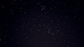 A serene night sky filled with stars and astrological symbols.