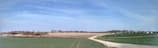 A panoramic view of the farm with fields and livestock.