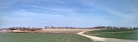Panoramic shot of a peaceful Yucatan landscape showing multiple divided plots under a clear blue sky.