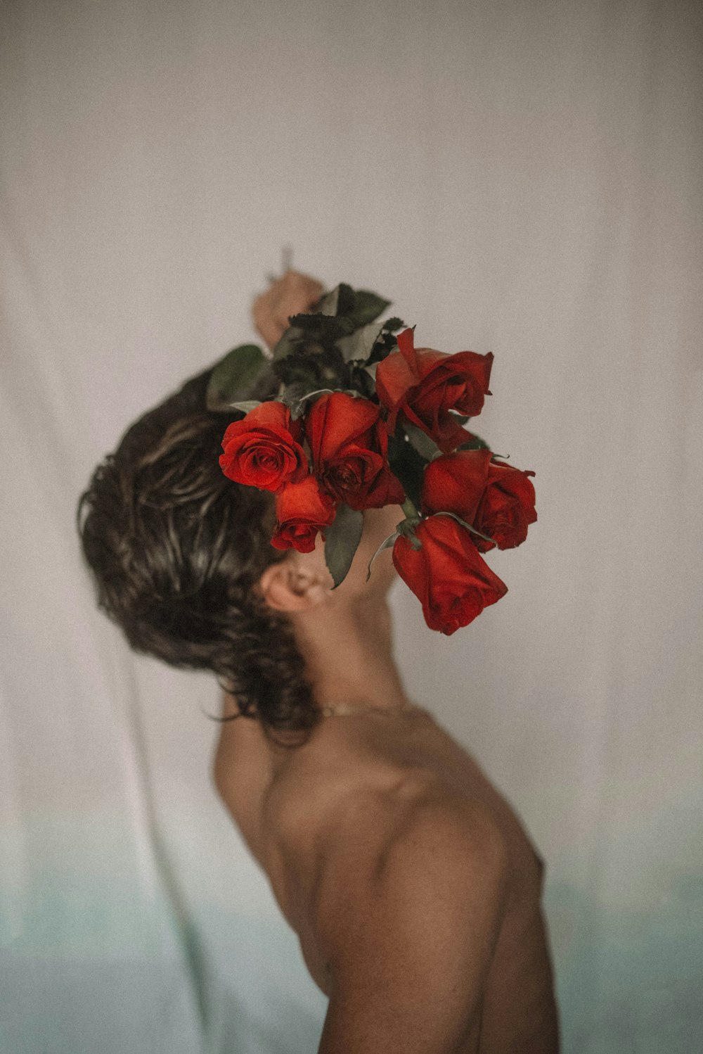 topless woman holding red roses