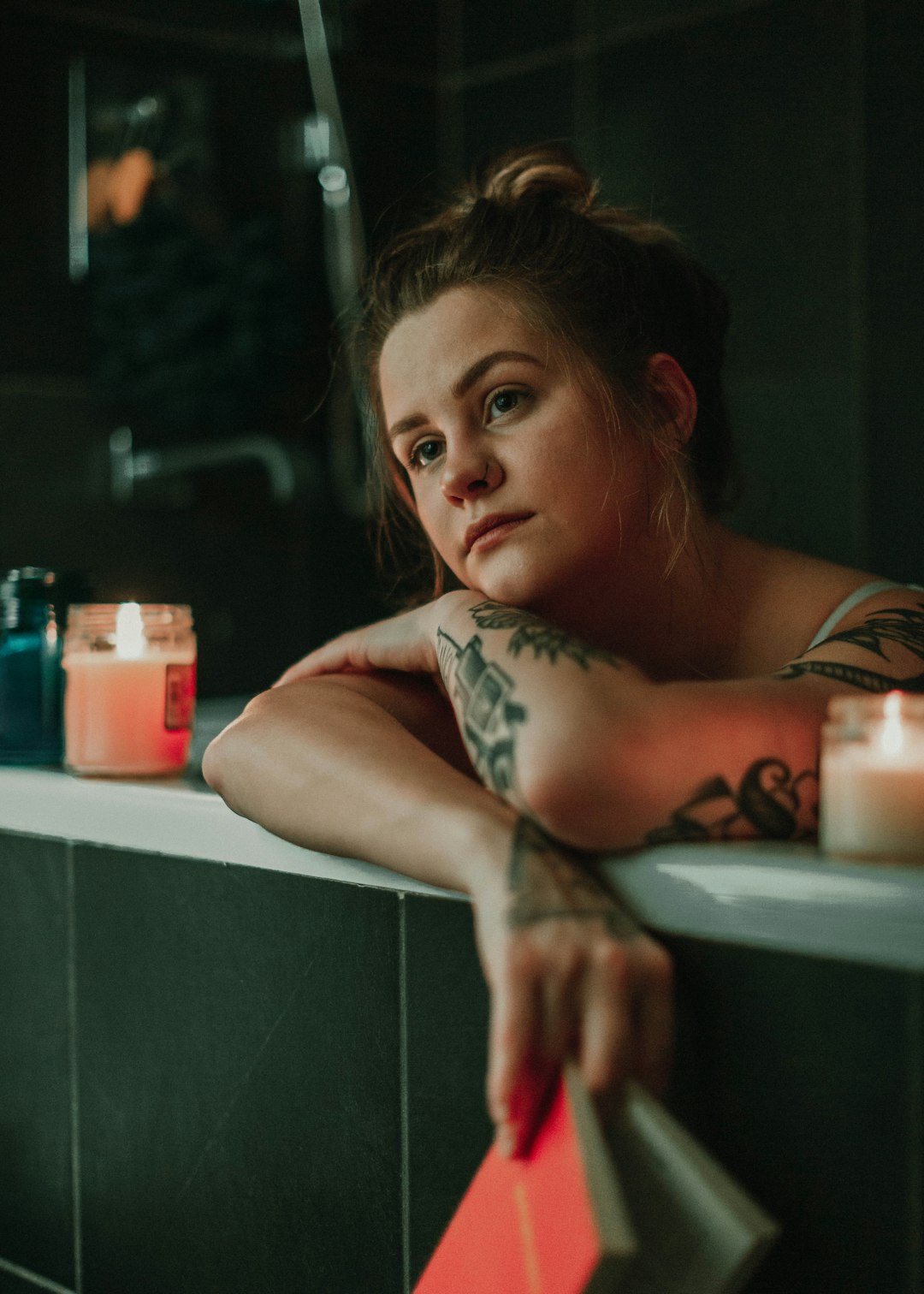 woman in white and black floral sleeveless top lying on white ceramic bathtub