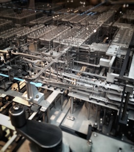 A complex network of mechanical gears and components, featuring metallic structures and various intricate parts aligned in a precise, orderly fashion.