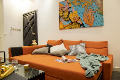 A vibrant sofacum bed in a cozy studio apartment with colorful throw pillows.