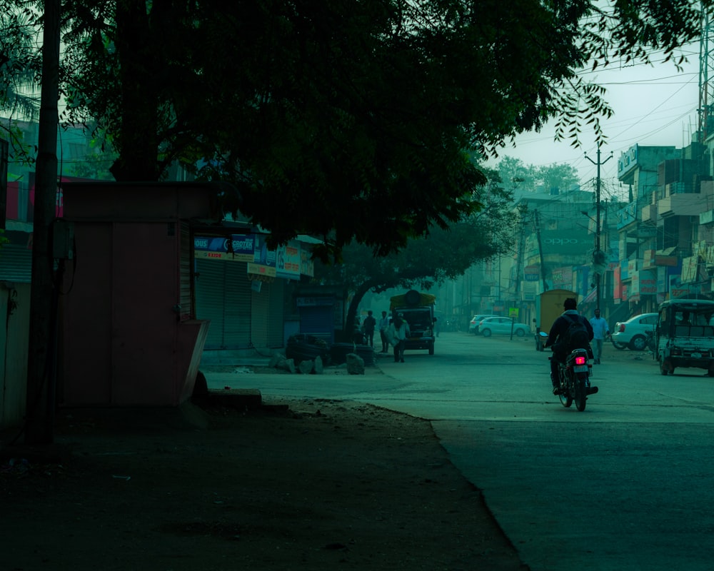 man in black jacket and black pants riding on motorcycle on road during nighttime