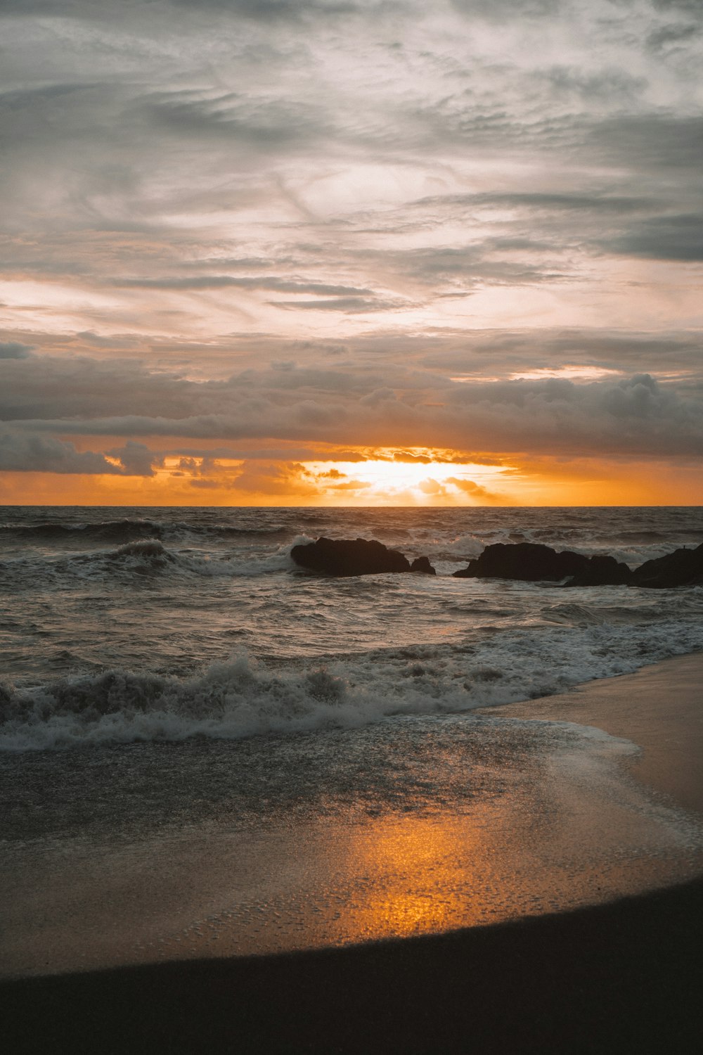 sea waves crashing on shore during sunset