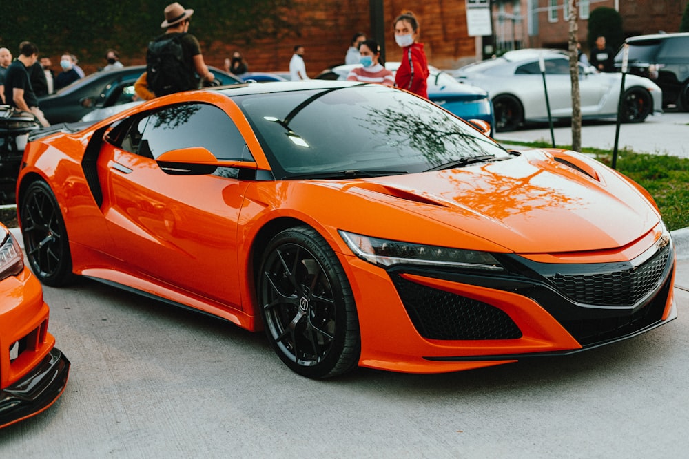 orange lamborghini aventador parked on gray pavement during daytime