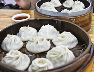Golden fried dumplings arranged neatly on a bamboo steamer with dipping sauce on the side