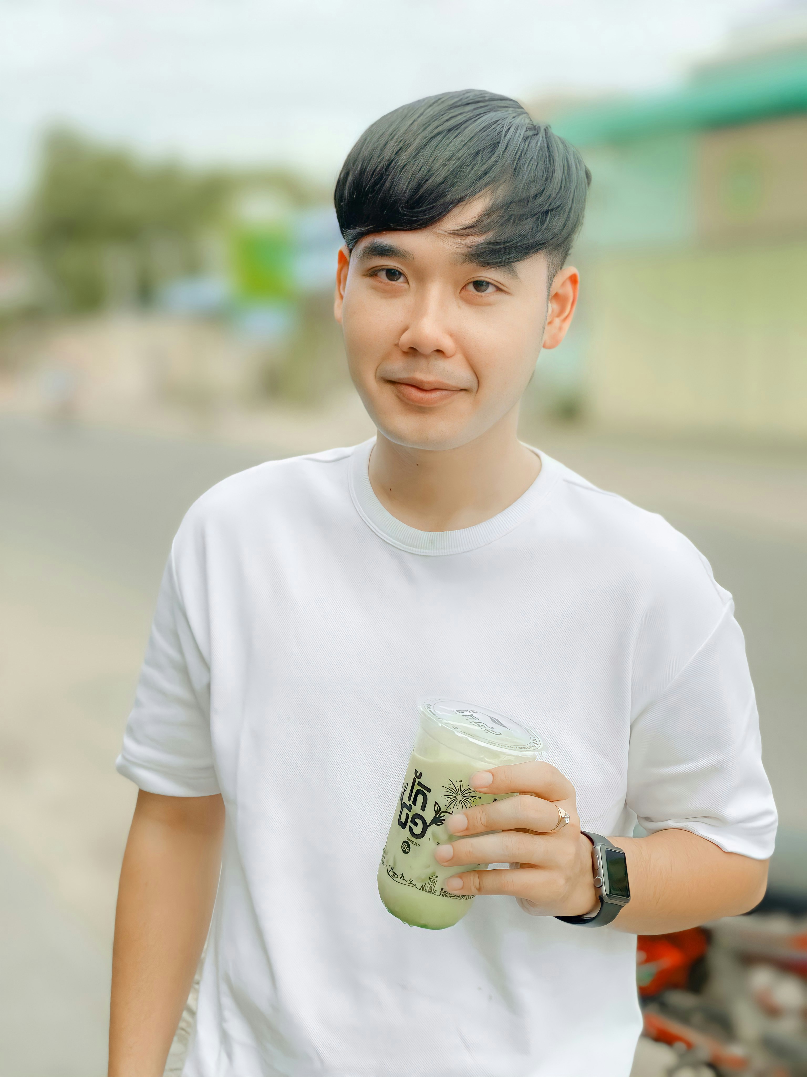 boy in white crew neck t-shirt holding green and white ceramic mug