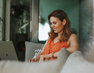 woman in orange sleeveless top sitting on couch